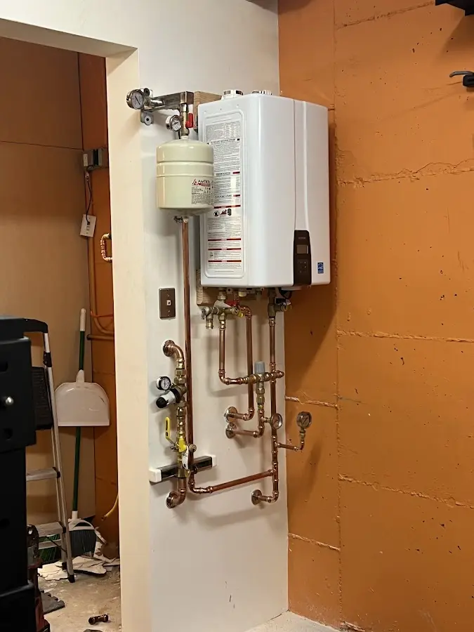 Plumbing technician inspecting water heater connections in Wapato